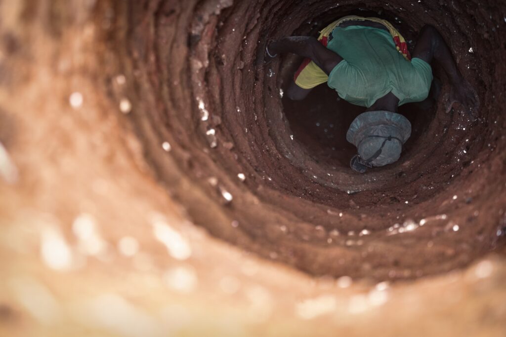 A man going down the mica pit to mine mica © Aelle Studio